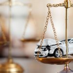 Courtroom scales of justice and a broken car.