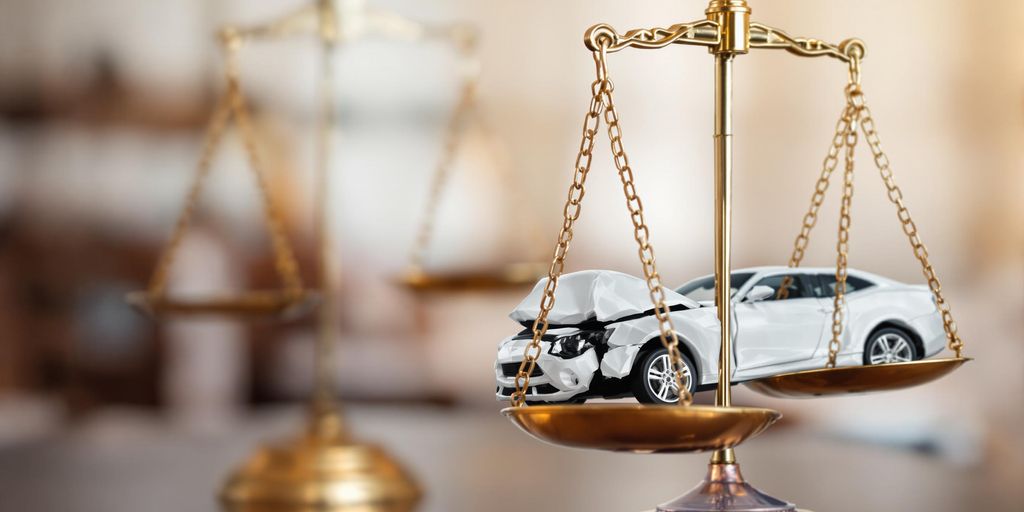 Courtroom scales of justice and a broken car.