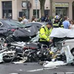 Motorcycle accident scene with responders and injured rider.