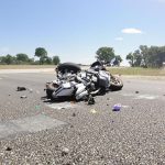 Motorcycle accident scene with road and debris.