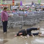 Person slipping on wet grocery store floor with spilled groceries.