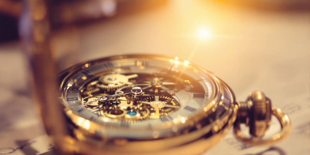 Close-up of a vintage pocket watch, gears visible, bathed in sunlight.