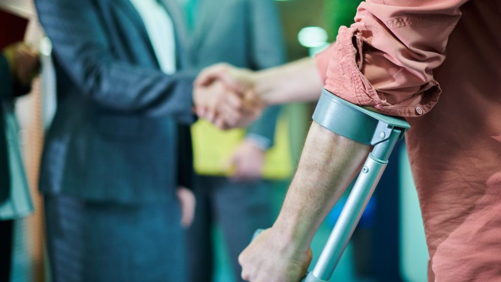 a person on a crutch with a hand shake for car accident lawyer