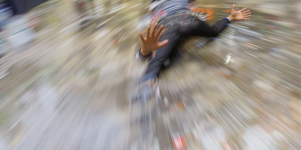 Person slipping on wet floor inside a building.