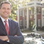 Attorney beside motorcycle outside courthouse in Douglasville