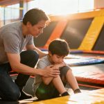 Parent comforts child after trampoline park accident.
